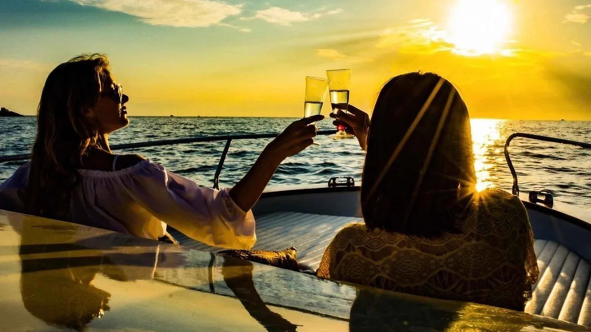 Boat with passengers enjoying a sunset aperitif cruise along the Cinque Terre coast from La Spezia