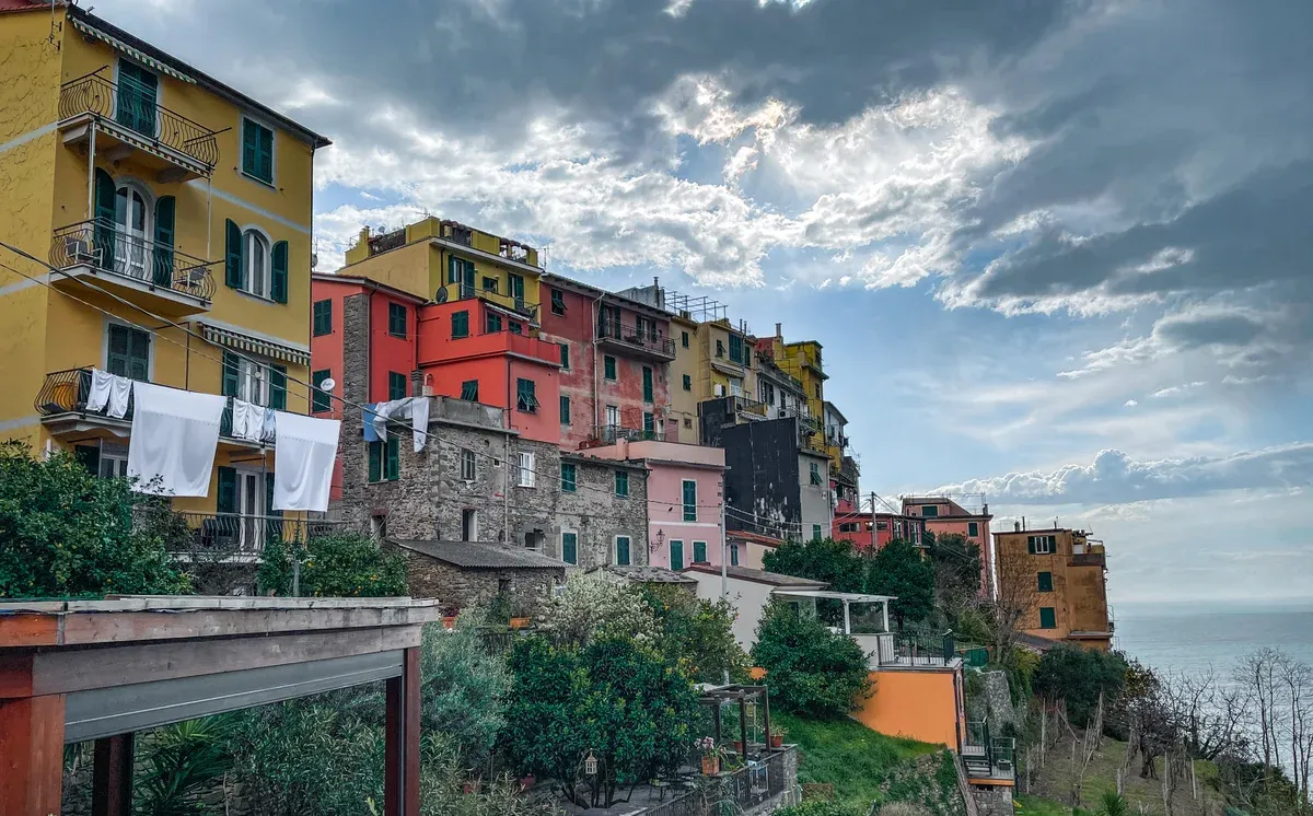 Corniglia seen from the sea, Cinque Terre, the village stacked on its high promontory above terraced vineyards